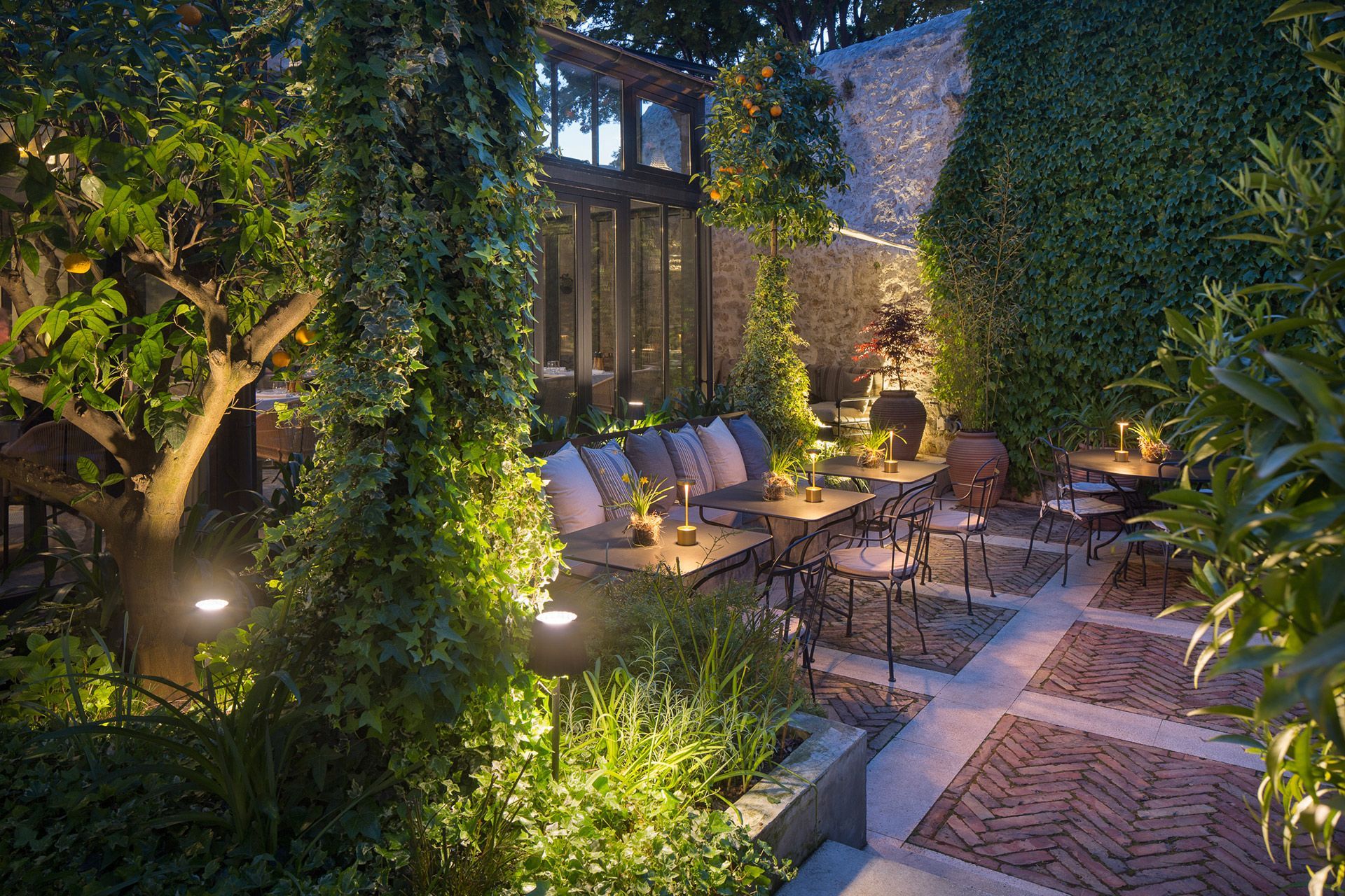 Discover the allure and boutique ambience of Almayer Art & Heritage Hotel's secret garden, where the elegant Corte Restaurant resides within an enchanting glass and steel Orangerie