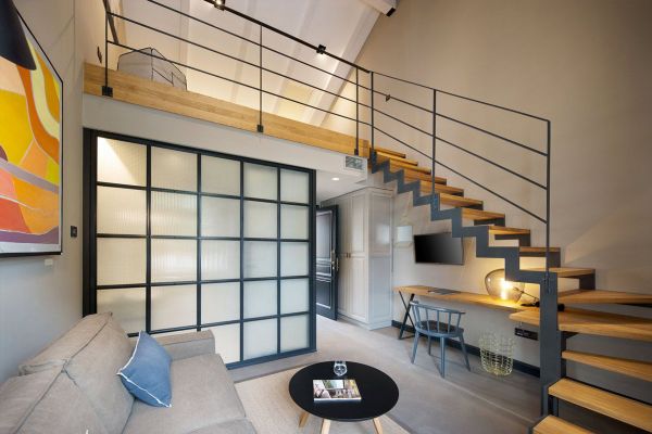Inviting living area in Deluxe mezzanine double room 'Ostro' at Almayer Art & Heritage Hotel, featuring stairs to the cosy mezzanine bedroom
