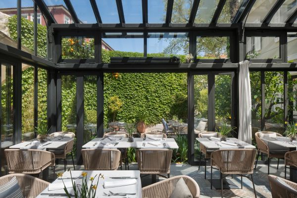 Immerse yourself in the radiant atmosphere of Corte Restaurant, housed in Almayer's steel and glass Orangerie, enveloped by a lush secret garden