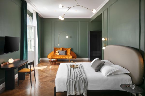 Explore the generous proportions of the Deluxe double room 'Gjika' in Almayer Art & Heritage Hotel's annexe building, offering a comfortable sofa and a luxurious king-sized bed