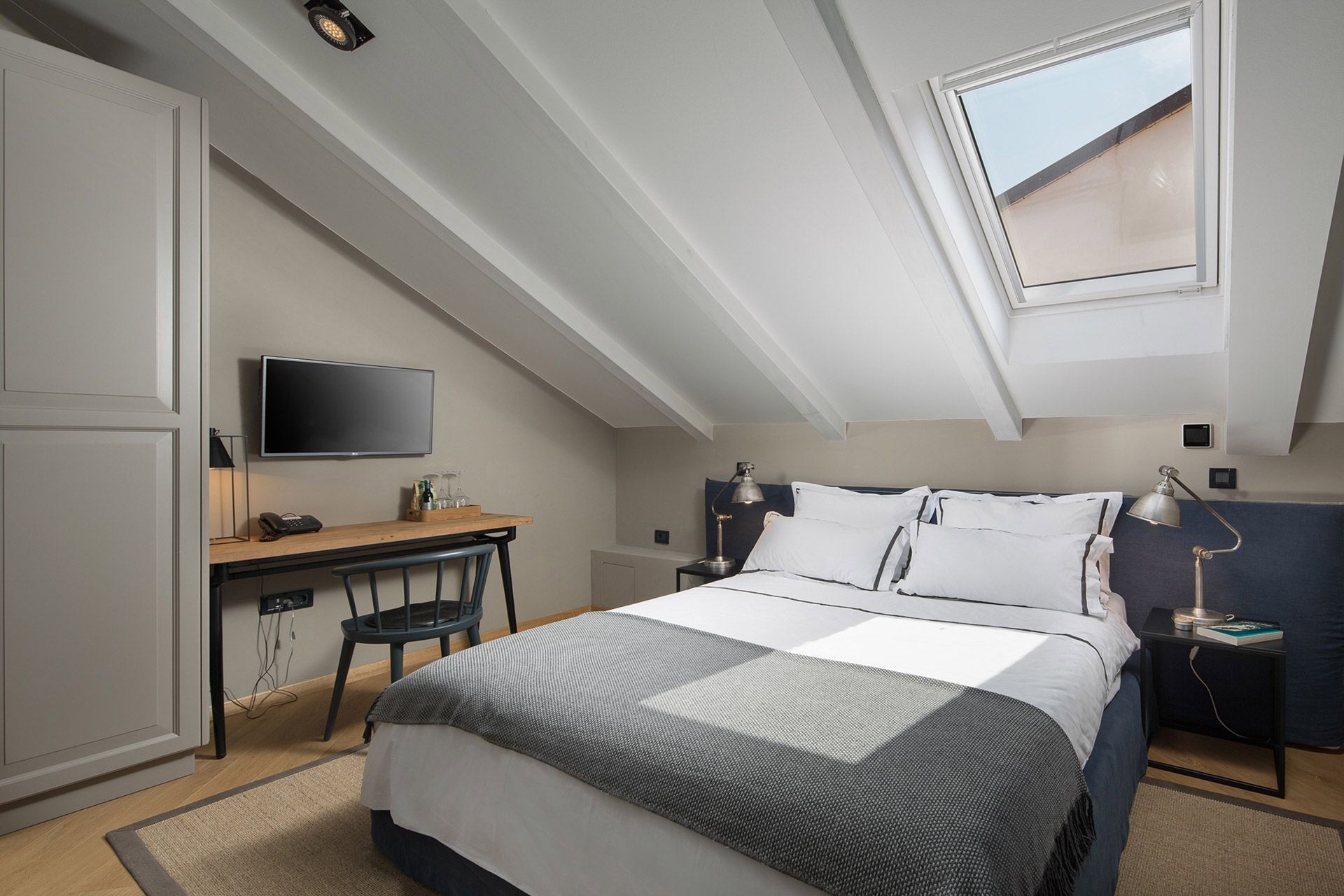 Intimate Almayer hotel’s standard double room La settima stanza with its king-size bed, desk, and tv