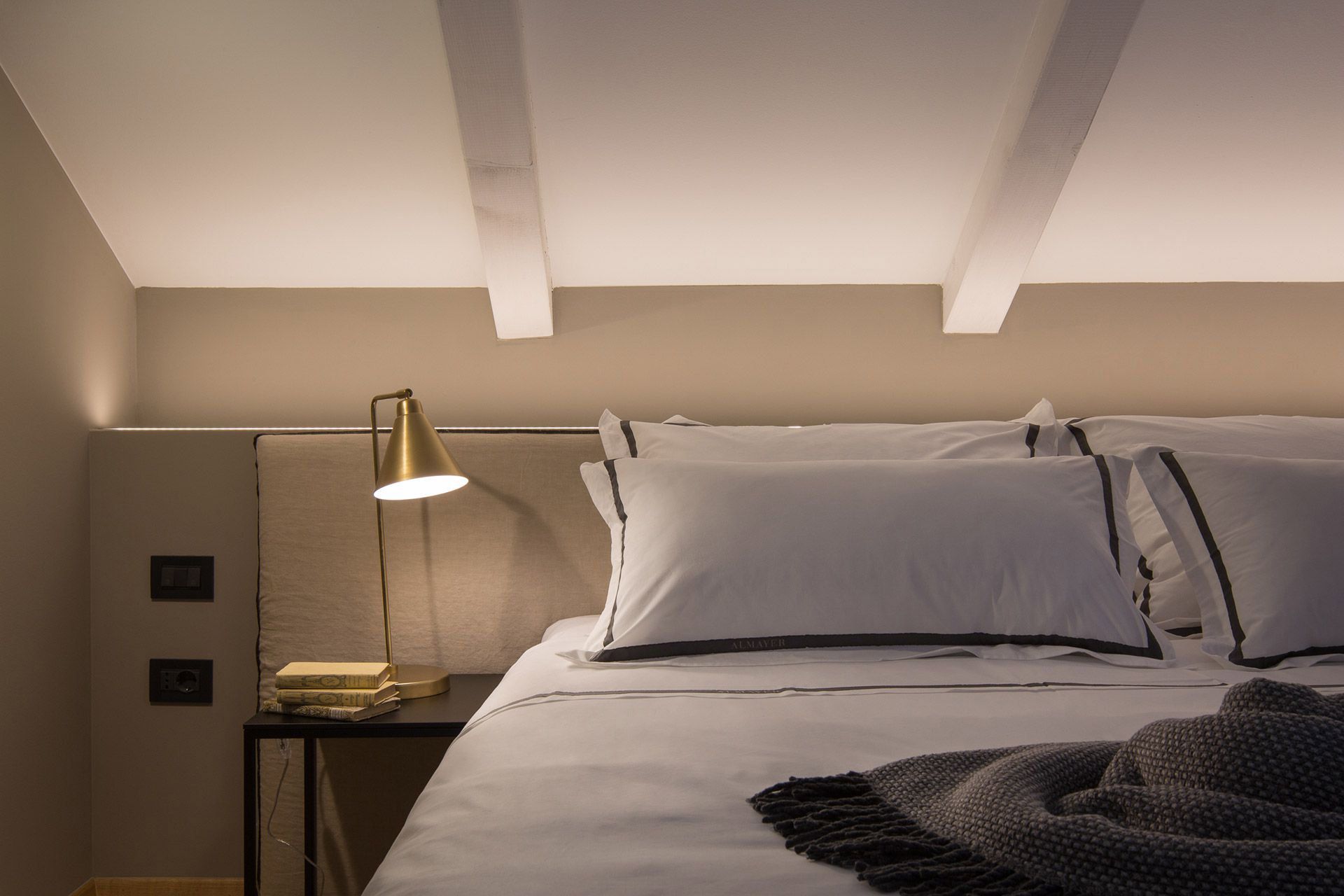 Warm mezzanine bedroom area with a comfortable king-size bed in Almayer hotel’s deluxe double room